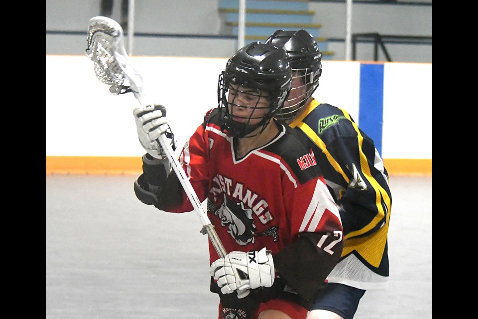 The Mustangs’ Cooper Bruce fights off the check of a Swift Current defender.