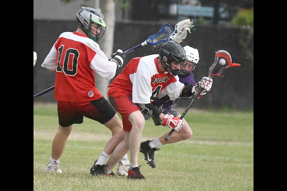Jake Williams comes up with a ground ball as Ethan Johnson looks on.