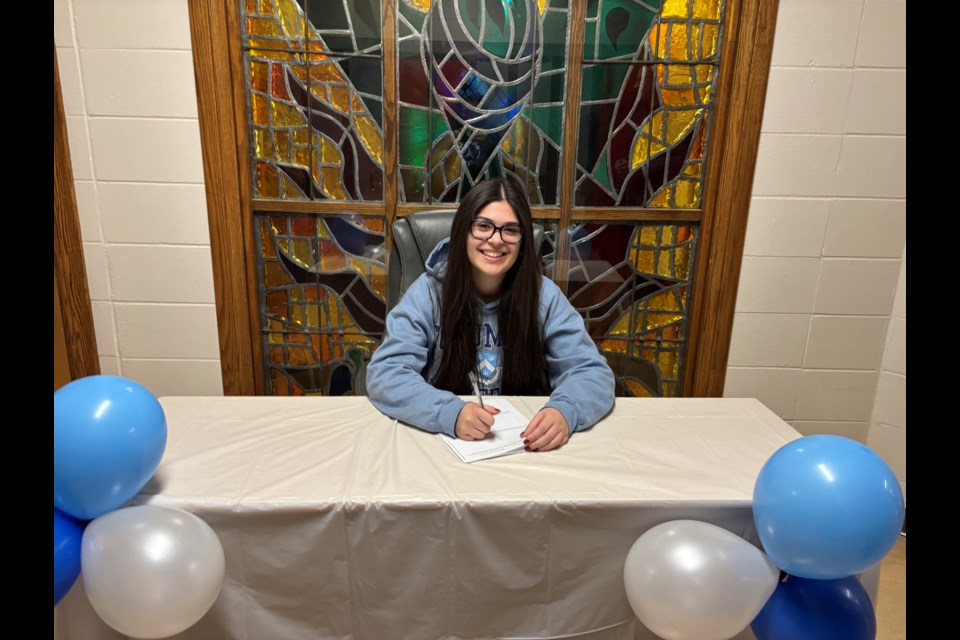 Leoncia White signs a scholarship agreement to join Columbia University's women's archery team. Photo submitted