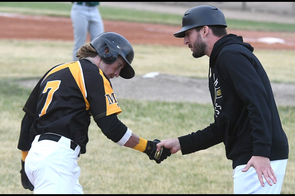 Michael Speck receives congratulations from coach Eric Marriott after his fourth-inning home run.