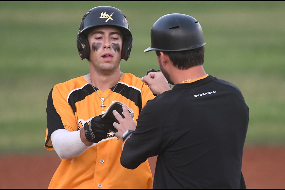 Joe Osborn receives congrats from head coach Eric Marriott after his run-scoring double in the fourth inning.