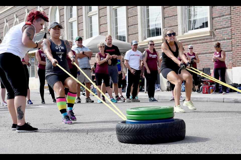 Jesse McLean of Gym & Tonic and Mandy Hougen from the Foremost Hustlers in action during the tire drag.