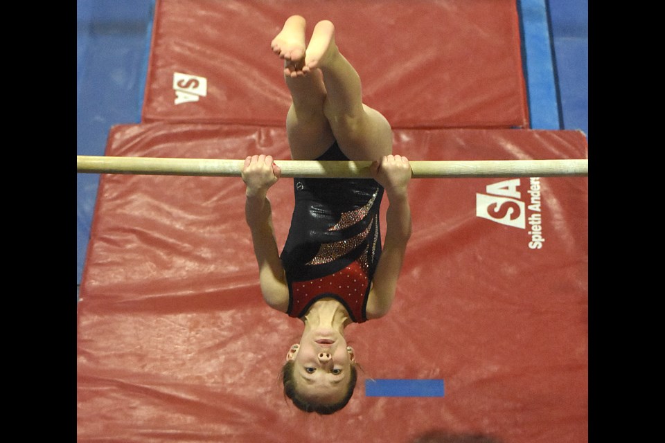 Gymtastiks' Alyssa Ofukany, 8, fights through the difficult portion of her uneven bar routine.