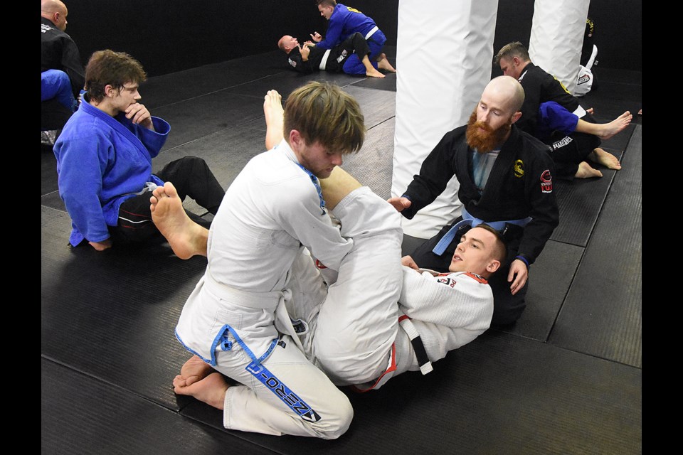 Control Jiu Jitsu instructor Cody Enns offers pointers to Martin Damianoff on how to properly apply an arm bar on training partner Rhett Busch.