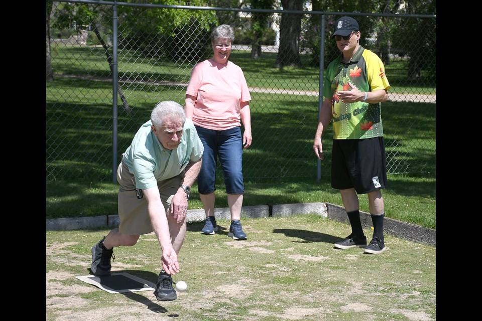 John Langford throws the jack as Moose Jaw Lawn Bowling Club president Daniel Morin offers instruction to Sharleen Langford.