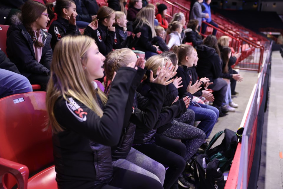 Young skaters from MJSC are applauding and watching the performers of Stars on Ice warm-up