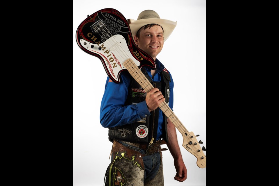 Dakota Buttar poses with the Alpha Bull champion’s guitar after winning the PBR Canada Touring Pro event at Mosaic Place on Saturday night. Alpha Bull/Todd Korol photo