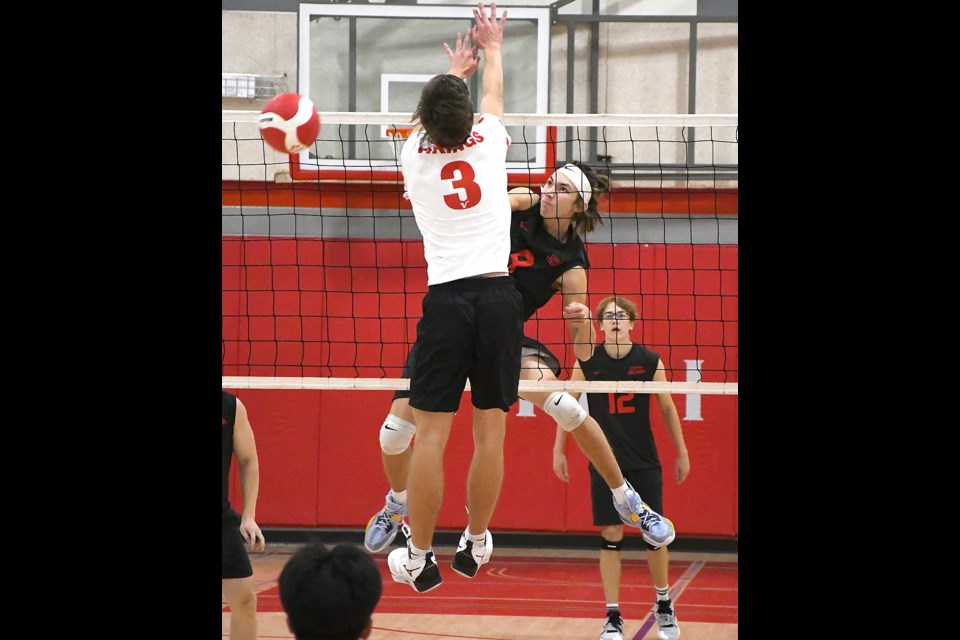 The Cyclones’ Talen Giraudier puts down a kill past the block of Vanier’s Jack Dueck.
