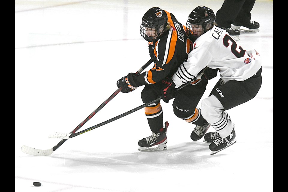Berkly Catton in action with the Saskatoon Contacts against Moose Jaw Warriors and current Saskatoon Blades forward Rowan Calvert during the 2021-22 season.