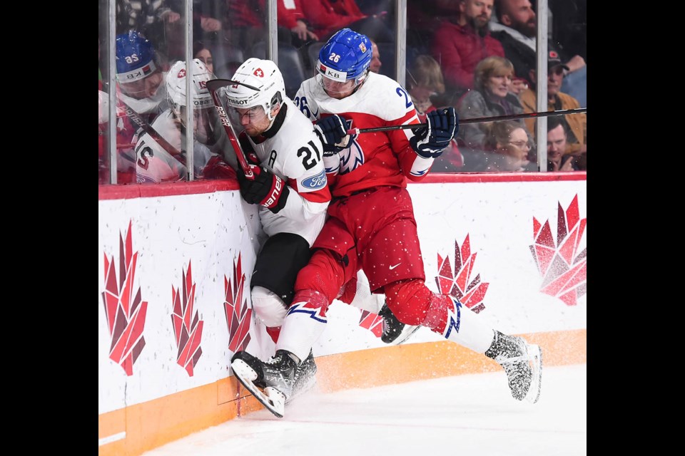 Moose Jaw Warriors and Team Czechia forward Martin Rysavy lays a big hit on a Swiss attacker during their quarter-final win. | IIHF.com