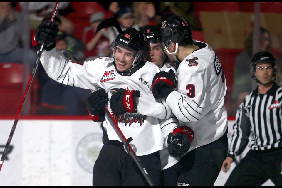 Brayden Yager celebrates his second goal of the game with Denton Mateychuk (back) and Lucas Brenton.