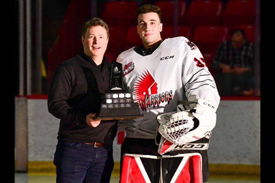 Carl Tetachuk accepts the Player of the Year award from Warriors president Chad Taylor.