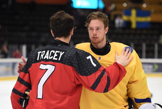 Moose Jaw Warriors and Team Canada forward Brayden Tracey congratulates Sweden goaltender Hugo Alnefelt on their semifinal win. Photo by Steve Kingsman/HHOF-IIHF Images.