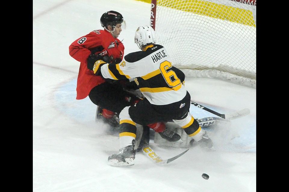 Moose Jaw Warriors forward Justin Almeida crashes into the Brandon goal with defenceman Chase Hartje. Randy Palmer photograph