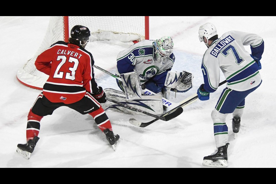 Warriors forward Atley Calvert gets off a shot in close on Broncos goaltender Reid Dyck during their first power play of the game.