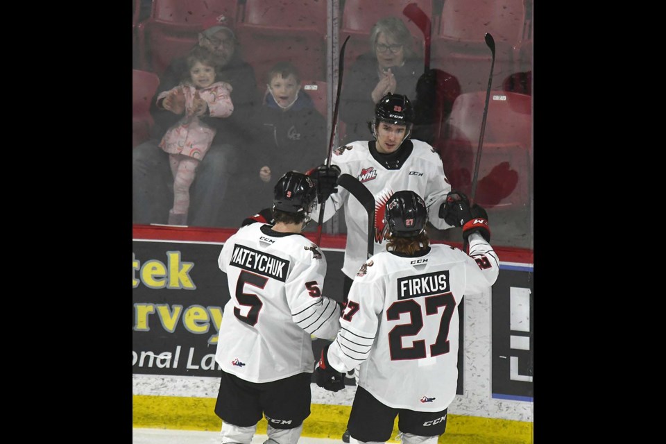 Warriors forward Brayden Yager celebrates his first goal with Denton Mateychuk and Jagger Firkus.