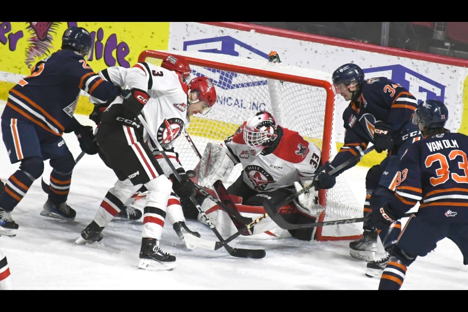 Warriors goaltender Dmitri Fortin keeps an eye on the puck during a goalmouth scramble in the first period.