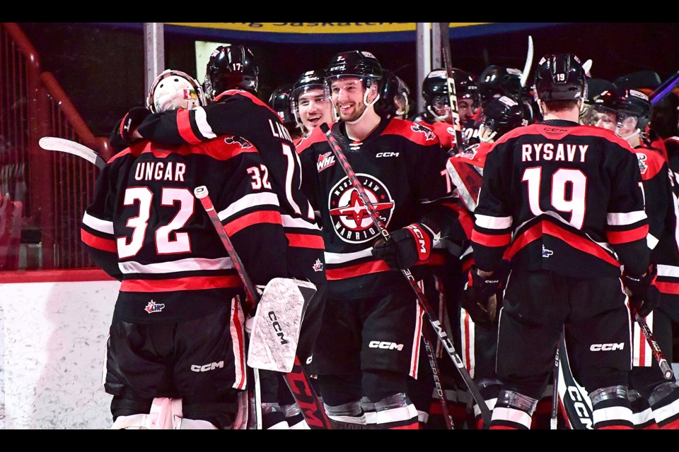 Warriors goaltender Connor Ungar joins his teammates in celebrating after their win in Game 1.