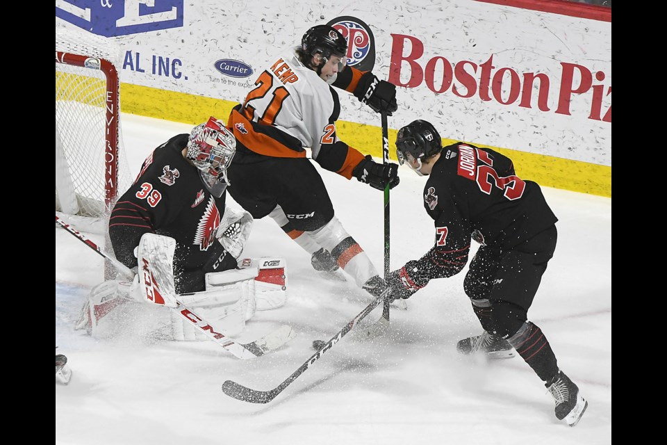 Medicine Hat’s Brett Kemp attempts to slip a backhand pass between Warriors goaltender Adam Evanoff and defenceman Cole Jordan.