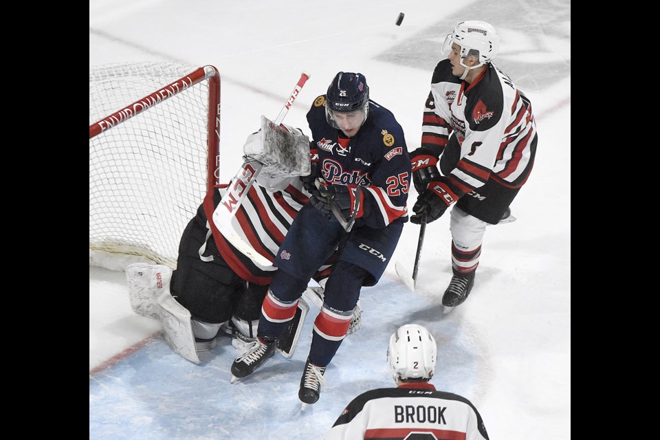 Blake Allan crashes past Warriors goaltender Brodan Salmond as Justin Almeida helps tie him up.