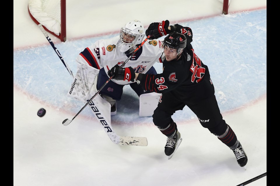 Warriors forward Riley Krane battles for the puck with Regina goaltender Matthew Kieper