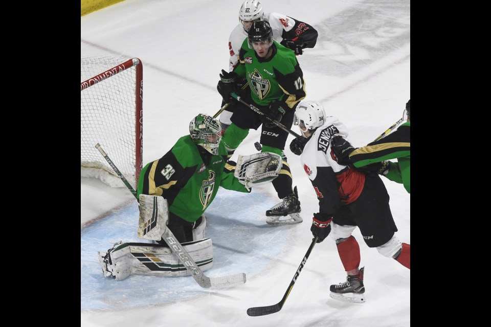 Carson Denomie keeps his eye out for the rebound in front of goaltender Ian Scott.