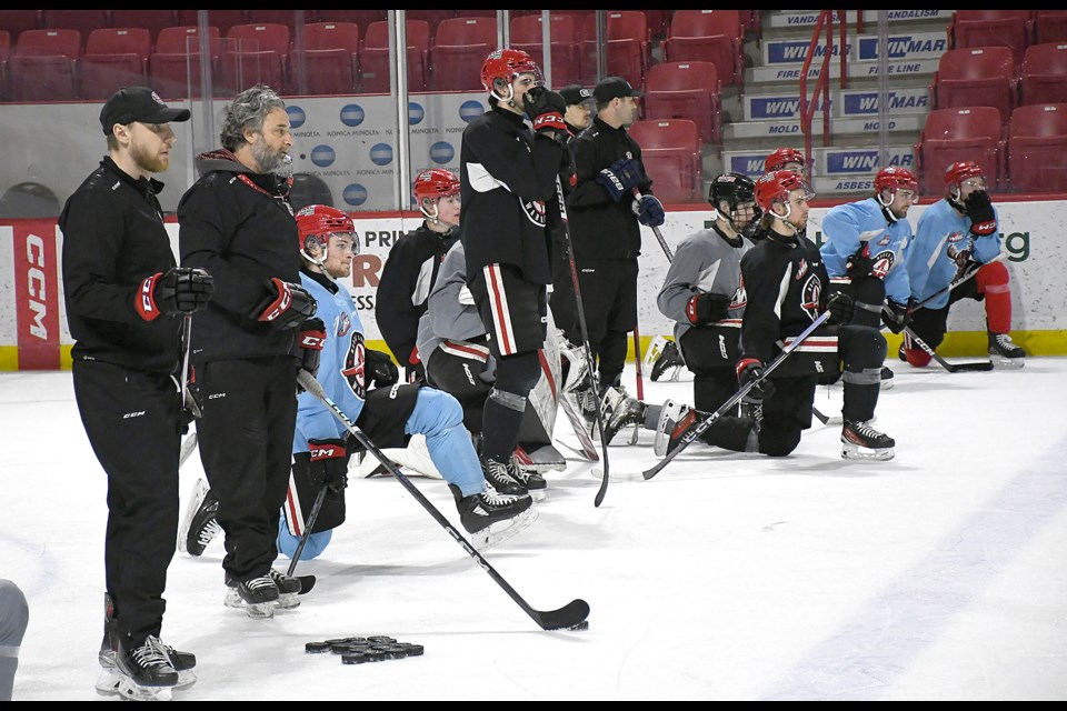 Members of the Moose Jaw Warriors keep an eye on the action during practice on Thursday.