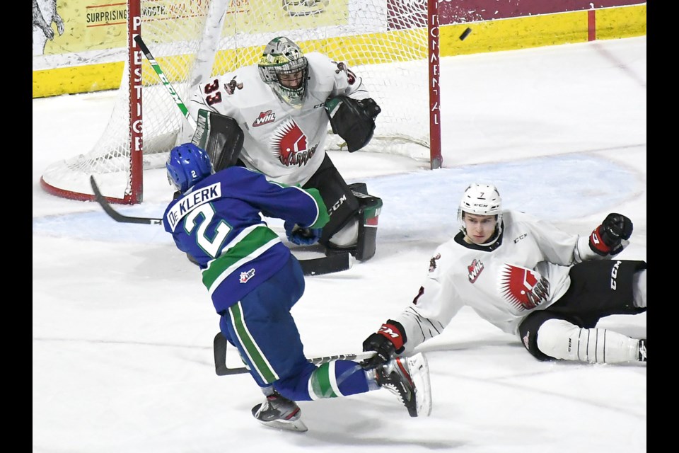 Warriors goaltender Boston Bilous turns aside a shot from Swift Current’s Hendrik De Klerk as defenceman Nolan Jones dives for the block.