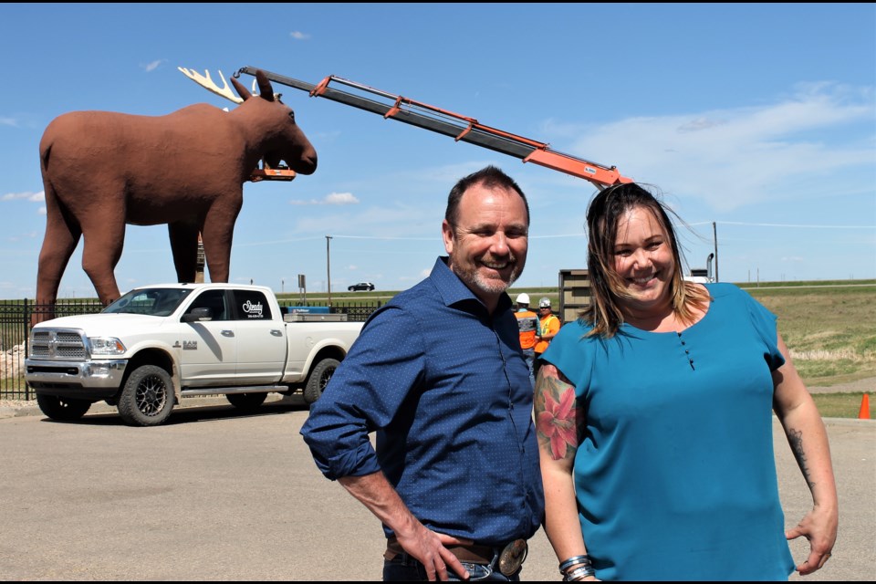 Mayor Fraser Tolmie and Tourism Moose Jaw executive director Jacki L’Heureux-Mason stand in front of a rare, one-antlered Mac the Moose.