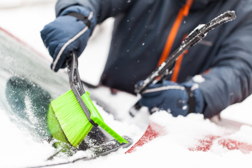 brushing snow off windshield shutterstock