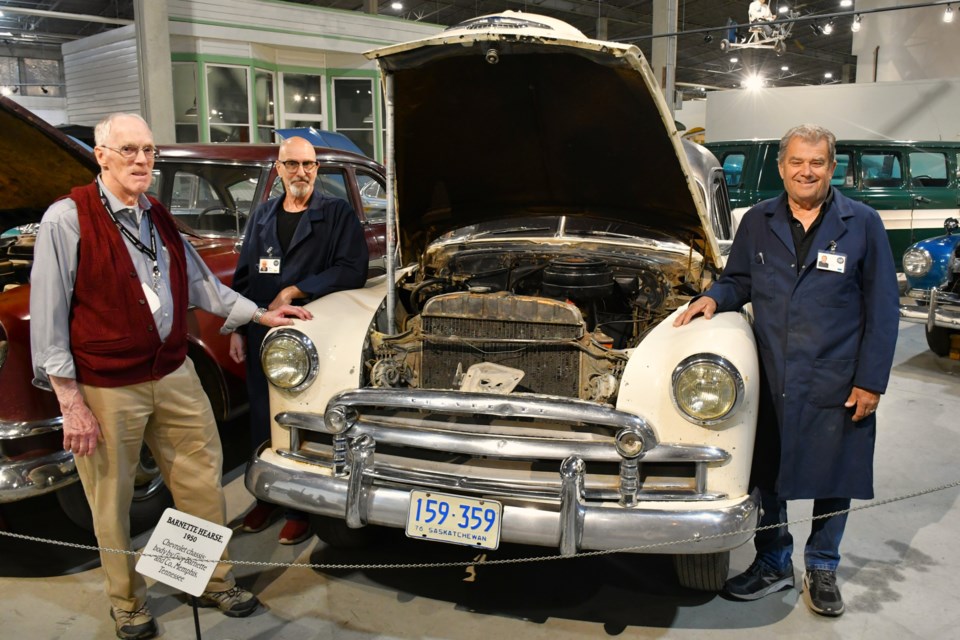 Volunteer detailing technicians Russell Wheatley (left), Mike Stobbs (centre), and John Westervelt (right) stand with the 1951 Barnette-built hearse they recently cleaned up at the WDM in Moose Jaw.