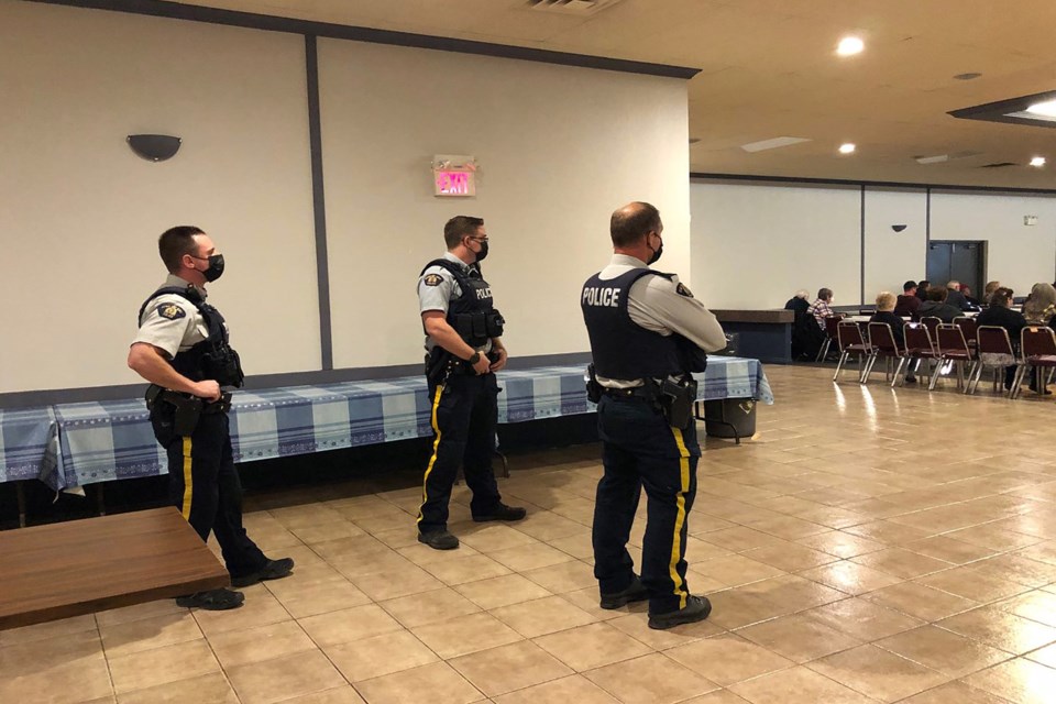 Three Innisfail RCMP officers stand at the back of the Innisfail branch of the Royal Canadian Legion hall moments after arriving following a call from chamber officials. 
Dan Singleton/MVP Staff