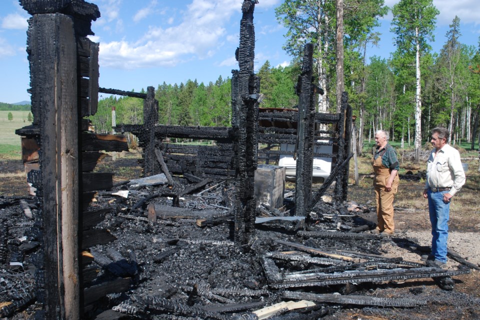 Ron Comfort, 70, and Linda Rose, 73, who live on a quarter section west of Sundre past the Bearberry Saloon, survey on Thursday, June 3 the wreckage of a barn that burned down near their residence on Saturday, May 29 when a brush fire went out of control and due to strong winds spread quickly to threaten several outbuildings. 
Simon Ducatel/MVP Staff 