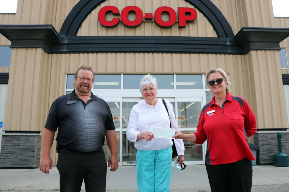 Judy Cooper, co-coordinator of the Innisfail and District Food Bank, centre, receives a cheque for $865 from Co-op's Joe Fletcher, the lumber manager at the Innisfail Farm and Home Centre, and Nancy Crawford, the store's assistant centre manager. Johnnie Bachusky/MVP Staff