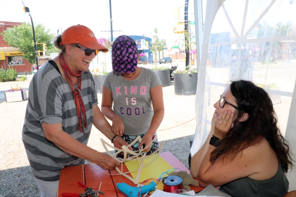 Red Deer County grandmother Joanna Mangan, left, with granddaughter Arianna Aris behind her, helps with lantern creating at an Innisfail Lantern Festival workshop on July 13 at the Market On Main. Johnnie Bachusky/MVP Staff