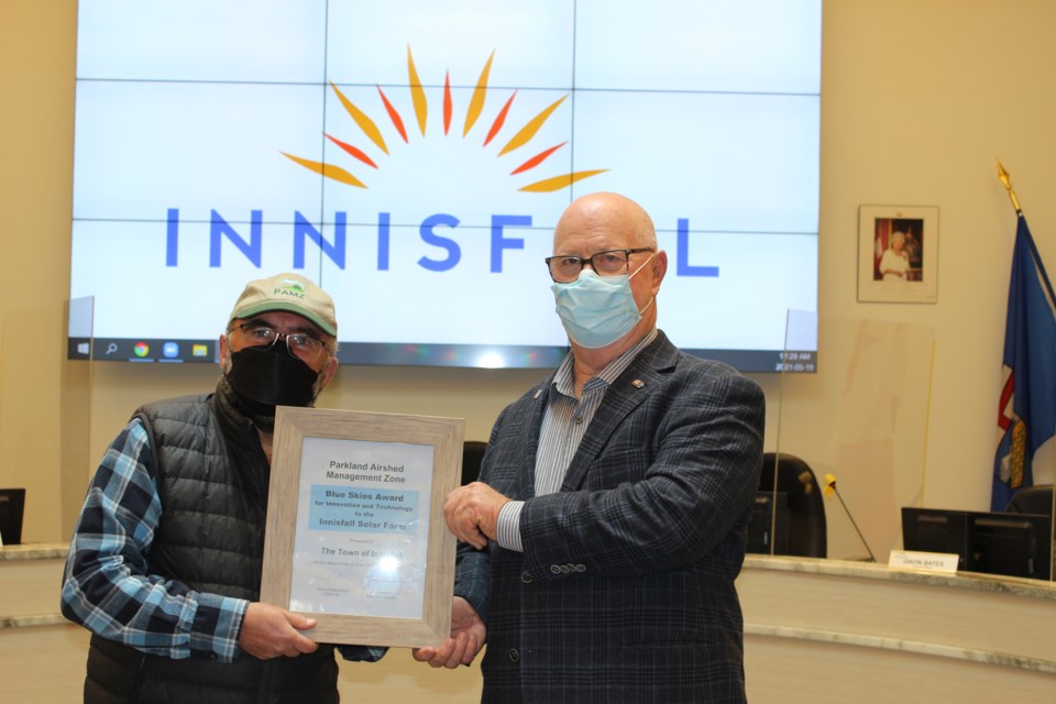 Kevin Warren, the executive director of the Parkland Airshed Management Zone, left, presents Innisfail mayor Jim Romane with the Blue Skies Award the town received last week. Town of Innisfail photo