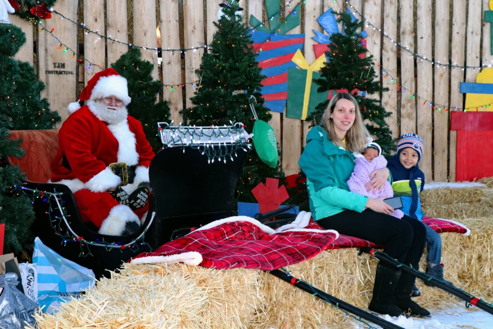 Innisfail mom Candace Ugorji brings her children to see Santa Claus at the Selfies with Santa display on Dec. 2 at the Kemp farm along Highway 54. From left to right is Santa, Ugorji, her nine-day-old daughter Victoria and three-year-old son Alexander. Johnnie Bachusky/MVP Staff