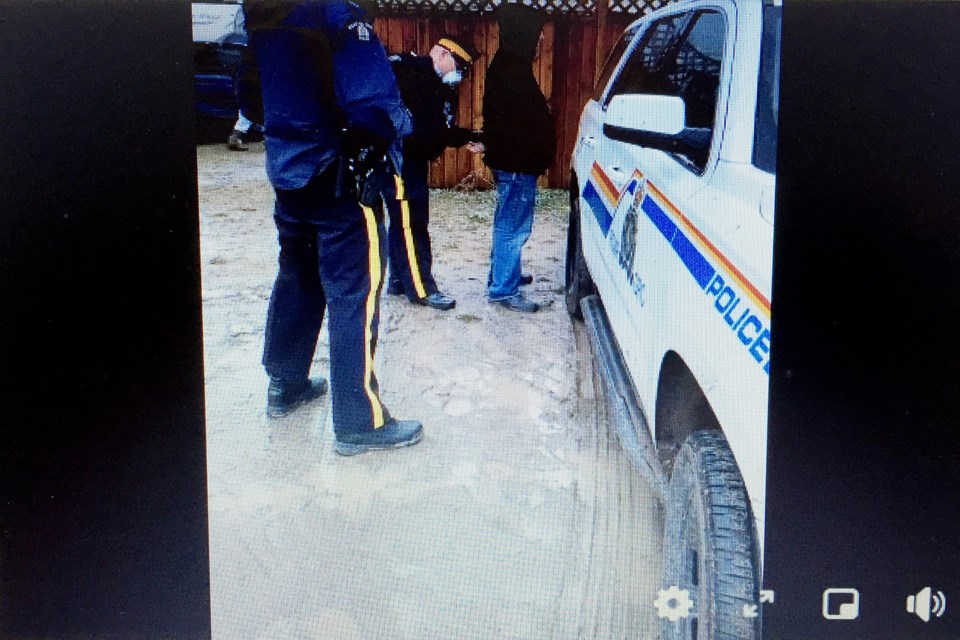 Chris Scott, the operator of the Whistle Stop Cafe in Mirror, right, is in police custody after being led away from his Save Alberta Campout Protest, which reportedly attracted about 2,000 supporters on May 8. Facebook video screenshot