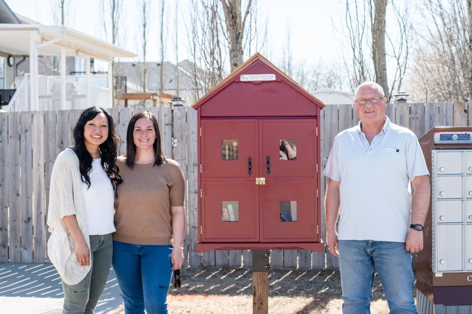 Neighbours Tasha Busch, left and Skylar Tooth and inspirational leader Brad Watson at the new Aspen Heights Free Library on April 16. Photo by Wilma Watson