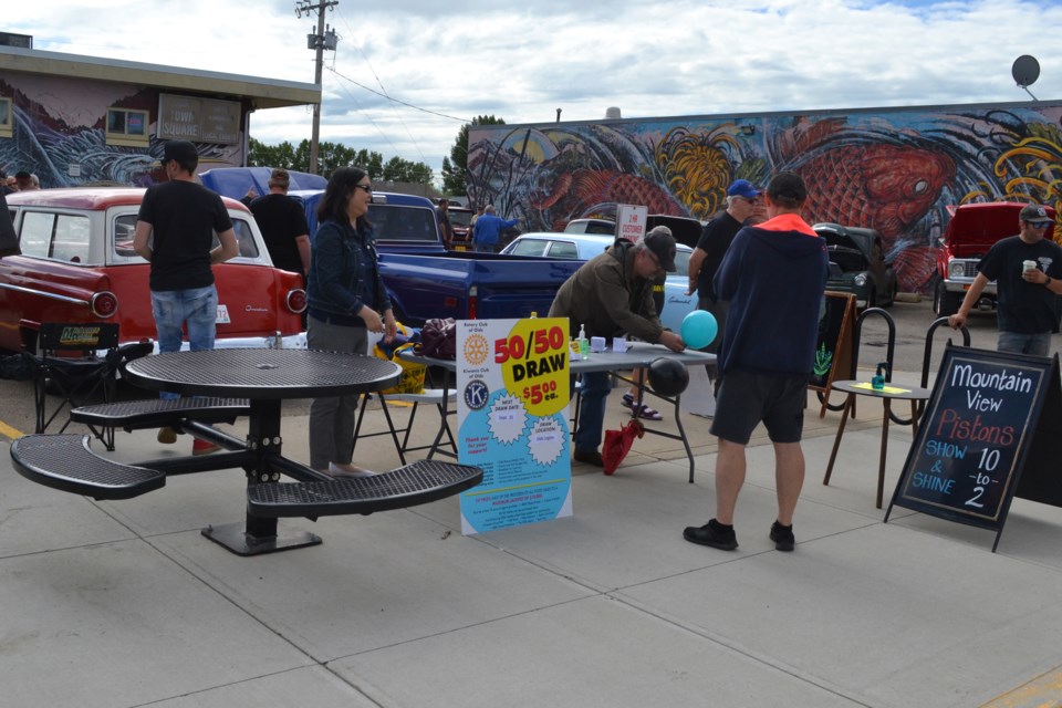 Volunteers sell tickets for the The Rotary Club of Olds and Kiwanis Club of Olds 50/50 draw during Coffee, Kombucha and Classic Cars, held July 18 at the Town Square in Uptowne Olds. The show was organized by members of the Mountain View Pistons and Uptowne Olds committee.
Doug Collie/MVP Staff