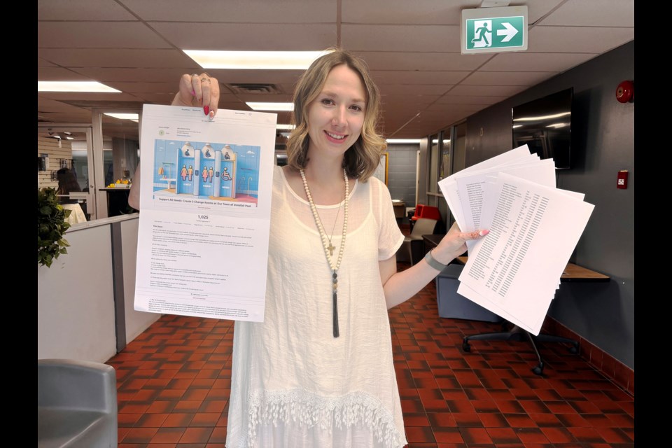 Innisfail's Emily Mburugu at the Innisfail Aquatic Centre last week with a print out of her petition last week calling for the Town of Innisfail to reconsider the universal change room plan for the facility's modernization.  Johnnie Bachusky/MVP Staff