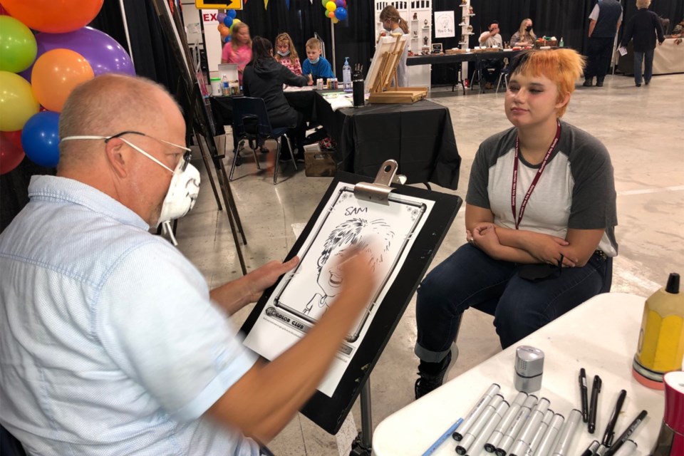 Mark Cromwell from Calgary works on a caricature drawing in the curling rink. He has more than 30 years experience as a artist.
Dan Singleton/MVP Staff
