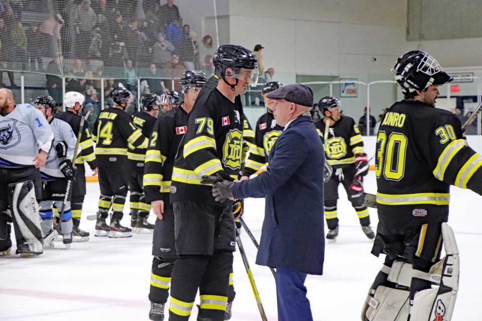 Gary Leith, coach of Innisfail Fire Rescue, is on the ice congratulating his team following his team's 9-8 victory over the Innisfail RCMP hockey team at the second annual Battle of the Badges charity hockey at the Innisfail Twin Arena on Jan. 5. Johnnie Bachusky/MVP Staff