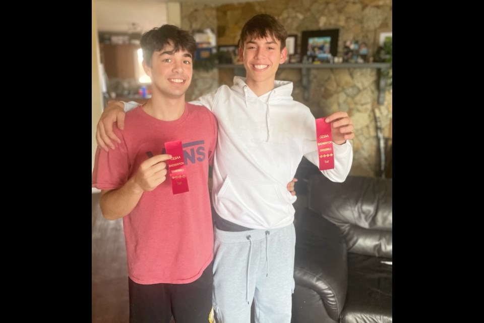 Christian and Ryder Persson display the first place ribbons they received in badminton competition.