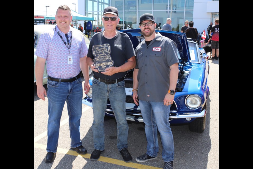 Kent Vaniderstine, centre, won Best in Show for his 1968 Mustang. The plaque was presented to him by  Cam Clark Ford general manager Justin Menard, left, and sales manager Robin Brooke, right.
Doug Collie/MVP Staff