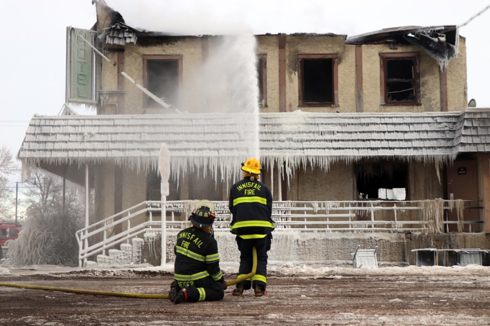 Innisfaill firefighter/pump operator Johnathon Schneider and probationary firefighter Adam Dingman battle the final hot spots of the fire that levelled the abandoned Bowden Hotel on New Year's Day. The pioneer building was then demolished later the same day. Johnnie Bachusky/MVP Staff