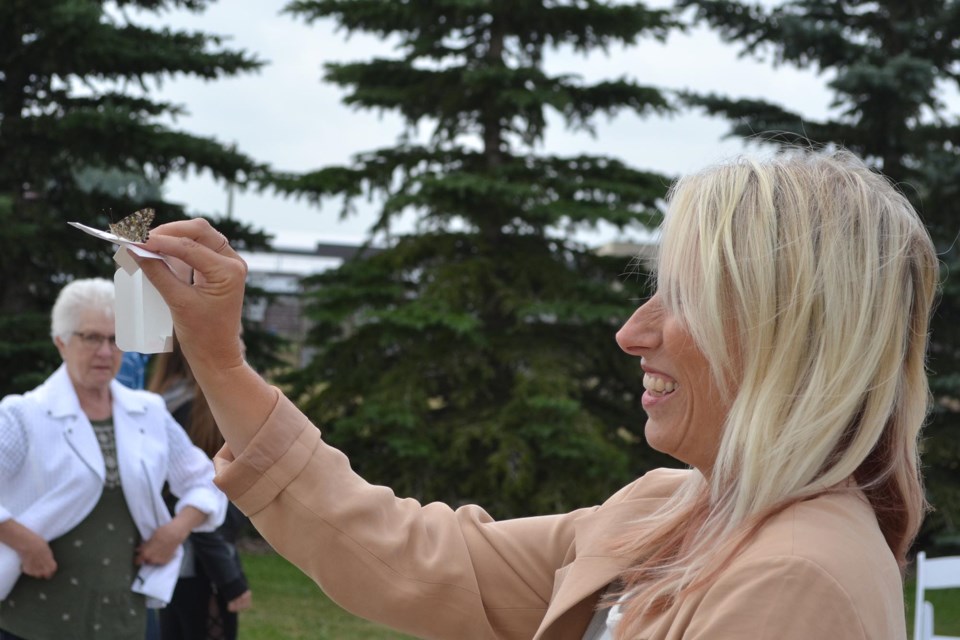 Pastor Melissa Furst  tries to release a butterfly during the Olds & District Hospice Society's butterfly release, held July 17 at the Olds College wetlands.
Doug Collie/MVP Staff