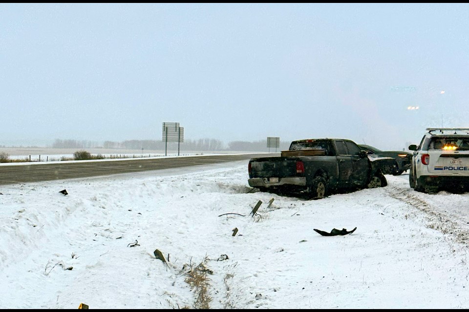 Sheryl Knock's extensively damaged 2012 Dodge Ram 1500 pickup truck lies in the median next to a RCMP police cruiser. Olds RCMP have launched an investigation to locate the hit and run driver who crashed into her near the Olds overpass on Highway 2. 
Submitted photo