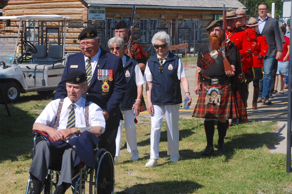 About two dozen people attended the annual Canada Day flag raising ceremony at the Sundre & District Museum's pioneer village. Royal Canadian Legion Sundre Branch #23 member Harvey Shevalier, front, joined the ceremony aided by fellow member Bill Edwards. Members of the Sundre RCMP detachment, local dignitaries, and MLA Jason Nixon, background, also participated. 
Simon Ducatel/MVP Staff