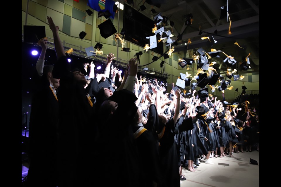 Following tradition, the grads tossed their caps into the air at the  end of the cap and gown ceremony.